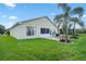 A lush backyard features a paver patio with outdoor seating and beautiful palm trees at 348 Lake Suzanne Dr, Lake Wales, FL 33859