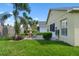 A well-maintained backyard with a paver patio, palm trees, and lush green grass at 348 Lake Suzanne Dr, Lake Wales, FL 33859