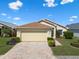 Charming single-story home with a two-car garage, landscaped front yard, and a brick driveway at 348 Lake Suzanne Dr, Lake Wales, FL 33859