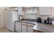 Well-lit kitchen with granite countertops, white appliances, and ample cabinet space for storage at 348 Lake Suzanne Dr, Lake Wales, FL 33859