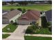 Aerial view of the home showcasing the lawn, roof, driveway, and surrounding neighborhood at 373 St Georges Cir, Eagle Lake, FL 33839
