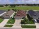 Features a well-maintained lawn, mature landscaping and a driveway leading to an attached garage in a suburban setting at 373 St Georges Cir, Eagle Lake, FL 33839