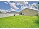 Exterior view of the home's backyard with white fencing and lush green grass at 373 St Georges Cir, Eagle Lake, FL 33839