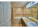 Bathroom featuring double sinks, tiled bathtub and glass shower door at 373 St Georges Cir, Eagle Lake, FL 33839