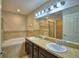 Bathroom with double sinks, tiled bathtub, and glass shower door at 373 St Georges Cir, Eagle Lake, FL 33839
