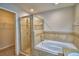 Bathroom featuring a tiled bathtub, glass shower door, and a walk in closet at 373 St Georges Cir, Eagle Lake, FL 33839
