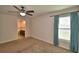 Bright bedroom with carpet, ceiling fan and a window with blue curtains at 373 St Georges Cir, Eagle Lake, FL 33839