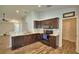 Modern kitchen with stainless steel appliances, dark wood cabinets, and wood-look flooring at 373 St Georges Cir, Eagle Lake, FL 33839