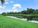 Scenic backyard with lush green grass and tranquil water views under a bright sky at 3802 Litchfield Loop, Lake Wales, FL 33859