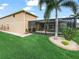 Green backyard with a covered lanai, lush lawn, landscaping, and exterior view of the home at 3802 Litchfield Loop, Lake Wales, FL 33859