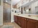Bathroom featuring a double vanity, wood cabinets, a walk-in shower, and decorative accents at 3802 Litchfield Loop, Lake Wales, FL 33859