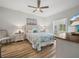 Cozy bedroom with a floral patterned bed, ceiling fan, and hardwood floors at 3802 Litchfield Loop, Lake Wales, FL 33859