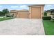 Charming home featuring a three-car garage, brick driveway, and manicured lawn at 3802 Litchfield Loop, Lake Wales, FL 33859
