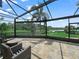 Screened in lanai with comfortable seating area, brick-patterned pavers, and gorgeous lake view at 3802 Litchfield Loop, Lake Wales, FL 33859