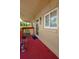 Cozy condo balcony with seating area, vibrant red floor, and natural light, creating a relaxing outdoor space at 400 El Camino Dr # 201, Winter Haven, FL 33884