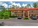 Charming condo building with red tile roof and mature landscaping near the parking lot at 400 El Camino Dr # 201, Winter Haven, FL 33884