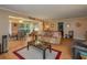 Open living room area with natural light, wood flooring, and seamless view into the dining space at 400 El Camino Dr # 201, Winter Haven, FL 33884