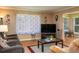 Living room area with comfortable seating, wood floors, and a view to the enclosed porch dining area at 400 El Camino Dr # 201, Winter Haven, FL 33884