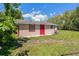 View of back of the home, highlighting the access door and green yard at 407 Snively Ave, Winter Haven, FL 33880