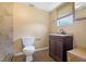 A simple bathroom features a vanity, mirror, toilet and window for ventilation and light at 407 Snively Ave, Winter Haven, FL 33880