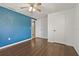 This bedroom features wood floors, blue accent wall, and access to closet and the bathroom at 407 Snively Ave, Winter Haven, FL 33880