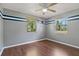 Charming bedroom with hardwood floors, ceiling fan and natural light from two large windows at 407 Snively Ave, Winter Haven, FL 33880
