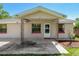 Charming covered front porch with decorative iron supports and a small front yard at 407 Snively Ave, Winter Haven, FL 33880