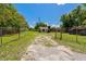 Gated front yard with a long driveway to a single Gathering home on a sunny day at 407 Snively Ave, Winter Haven, FL 33880