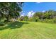A generous grassy lot with mature trees that offer shade and natural beauty at 407 Snively Ave, Winter Haven, FL 33880