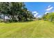 Expansive green lawn with scattered trees offers a serene and spacious outdoor setting at 407 Snively Ave, Winter Haven, FL 33880