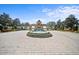 Scenic community entrance featuring a fountain and well-manicured landscaping and a gatehouse, leading into the neighborhood at 4254 Berwick Dr, Lake Wales, FL 33859