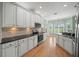 An open kitchen boasts stainless appliances, granite counters, wooden floors, and white cabinets at 4254 Berwick Dr, Lake Wales, FL 33859