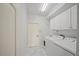 An organized laundry area features a washer, dryer, utility sink, and storage, all on marble tile at 4254 Berwick Dr, Lake Wales, FL 33859