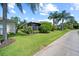 Well-maintained yard with lush green grass, neatly trimmed bushes, and tall palm trees at 4254 Berwick Dr, Lake Wales, FL 33859