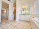 Bathroom showcasing tile flooring, a walk-in shower, vanity with a chandelier, and seamless flow to other rooms at 4469 Turnberry Ln, Lake Wales, FL 33859