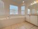 Relaxing bathroom featuring a soaking tub, tile floors, and ample natural light from multiple windows at 4469 Turnberry Ln, Lake Wales, FL 33859