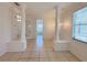Bright living room with tile floors, elegant columns, and seamless flow to adjacent rooms through glass doors at 4469 Turnberry Ln, Lake Wales, FL 33859