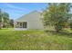 Well-maintained backyard with lush green grass, mature trees, and a screened-in patio at 529 Terranova Cir, Winter Haven, FL 33884