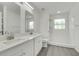 Modern bathroom boasts double sinks, white cabinetry and countertops, and a walk-in shower at 529 Terranova Cir, Winter Haven, FL 33884