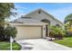 Charming home boasts a well-manicured lawn, gray roof and an attached two-car garage at 529 Terranova Cir, Winter Haven, FL 33884