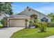 Charming one-story home featuring a well-manicured lawn, mature trees, and an attached two-car garage at 529 Terranova Cir, Winter Haven, FL 33884