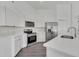 Modern kitchen with white cabinets, stainless steel appliances, quartz countertops, and a stylish faucet at 529 Terranova Cir, Winter Haven, FL 33884