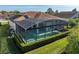 Aerial view of a home featuring a screened in pool enclosure and a well-manicured lawn at 5340 Nicklaus Dr, Winter Haven, FL 33884