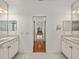 Bright bathroom featuring double vanity, light-colored tile, and an open doorway at 5340 Nicklaus Dr, Winter Haven, FL 33884
