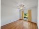 Bedroom features hardwood floors, ceiling fan, and window letting in natural light at 5340 Nicklaus Dr, Winter Haven, FL 33884