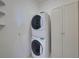 Stacked white washer and dryer appliances in a bright laundry area at 5340 Nicklaus Dr, Winter Haven, FL 33884
