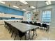 Well lit meeting room with neutral walls, tile floor, a quilt with a village pattern and rows of tables and chairs at 5340 Nicklaus Dr, Winter Haven, FL 33884