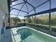 An in-ground pool sits inside of a screened in enclosure at 5340 Nicklaus Dr, Winter Haven, FL 33884