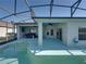 An in-ground pool sits inside of a screened in enclosure with an attached patio space at 5340 Nicklaus Dr, Winter Haven, FL 33884
