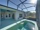 An in-ground pool sits inside of a screened in enclosure with an attached patio space at 5340 Nicklaus Dr, Winter Haven, FL 33884